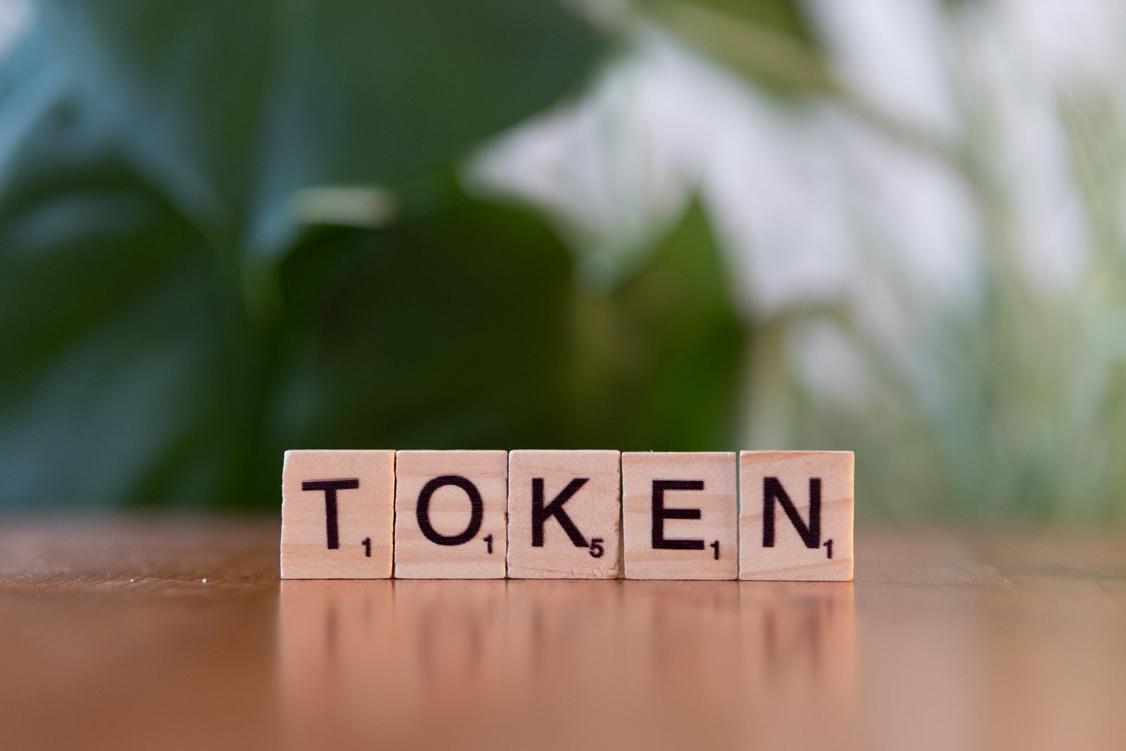 Scrabble Tiles Spelling 'Token' on Wooden Surface