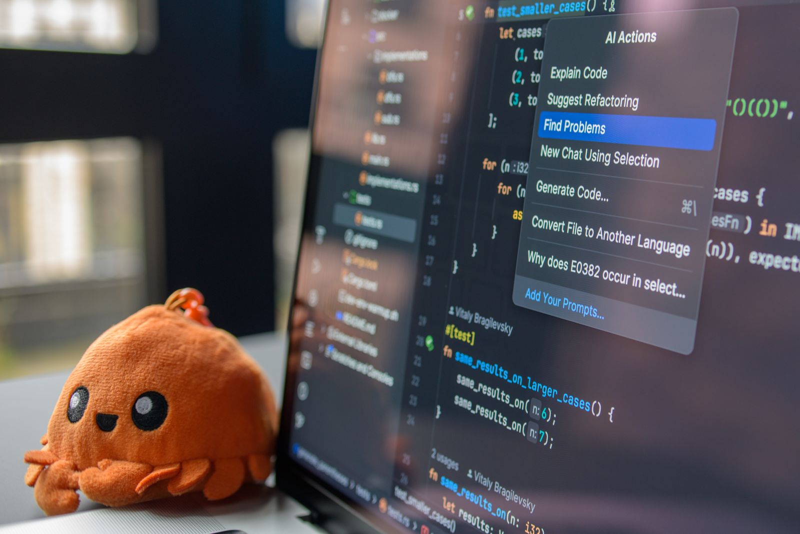 Laptop with Code Editor and Plush Crab Toy